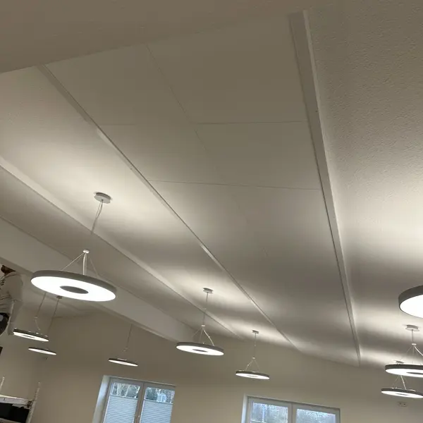 Die Decke eines weiß gestrichenen Raumes, an welcher weiße Akkustikplatten von der Malerei Norbert Bardtke montiert wurden.